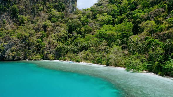 Drone Aerial Circle Movement Around Blue Lagoon and Secluded Paradise Beach with Palm Trees Swaying