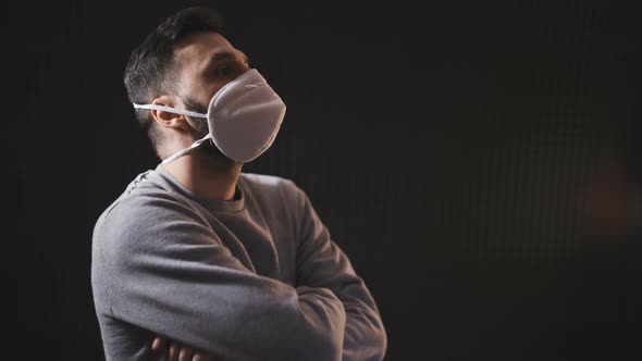 Side Profile of a Young Man Wearing White Face Mask for Protection and Prevention. Isolated on Black