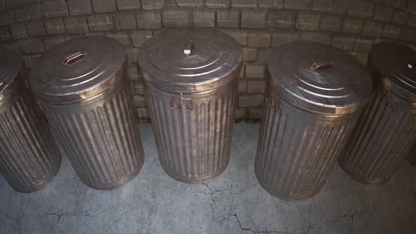 Steel trash bins stacked together in an endless loop lit by dim light. 4KHD