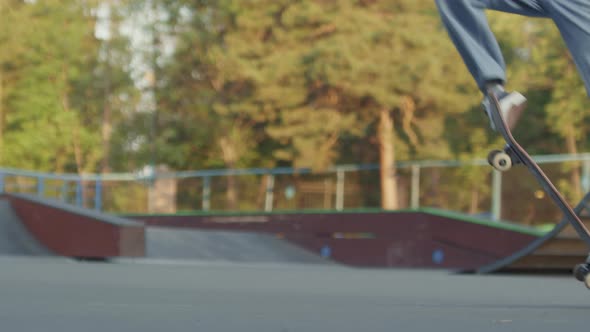 Low-Section of Teenager Doing Kickflip on Skateboard