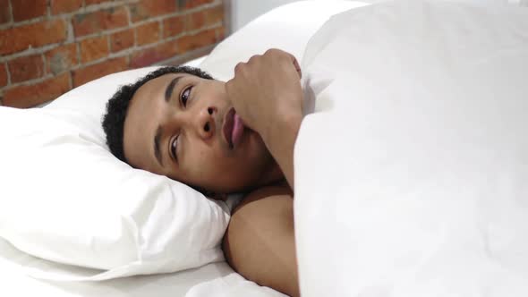 African Man in Lying in Bed Thinking and Imagining at Night