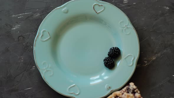 Piece of cake with blackberries and ice cream on a blue plate