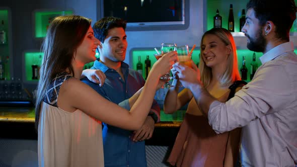 Friends having cocktail drinks at bar counter