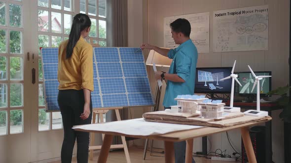 Asian Man And Woman Walk Into Discuss About Solar Cell In The Room