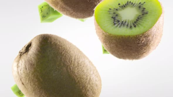 Kiwi with Slices Falling on White Background