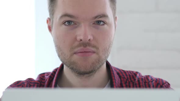 Thumbs Up By Young Man Working on Laptop