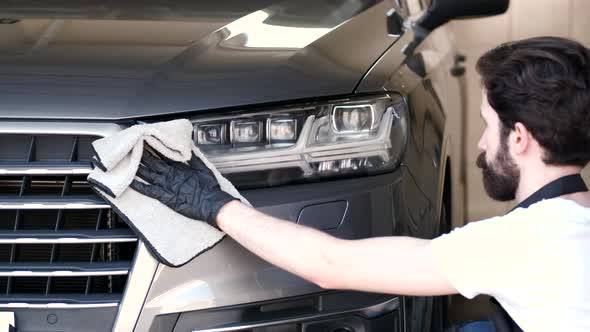 Man Wipes a Car in a Garage