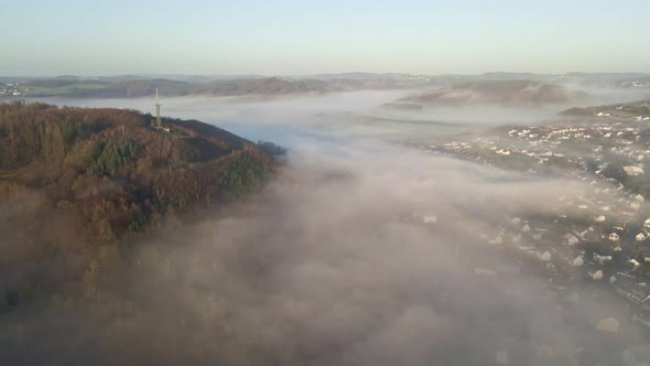 Misty sunrise in Morsbach, North Rhine-Westphalia with thick fog floating through the valleys of the