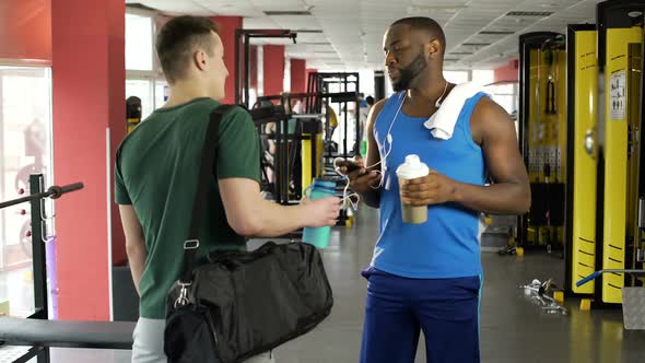 Two Athletic Men Talking at Fitness Club, Sportsmen Drinking Protein Cocktails