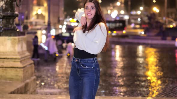 young woman performs modern dance steps on the street at night