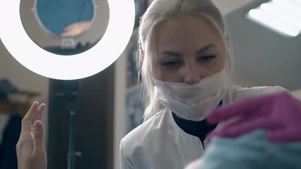 Cosmetologist Checks Client Eyebrows at Led Lamp Light