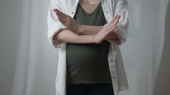 Front View Unrecognizable Pregnant Young Woman Crossing Hands Gesturing No Standing Indoors