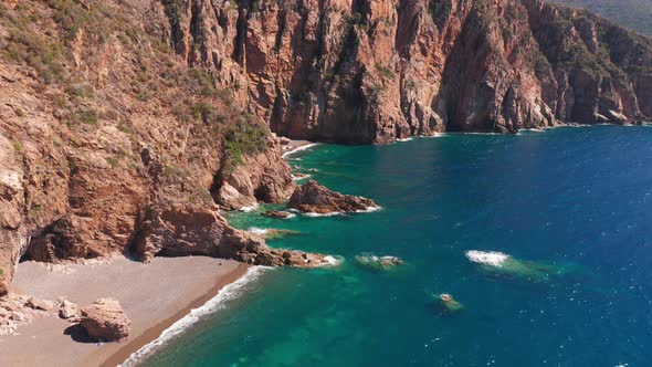 Aerial View of Red Rock Cliffs Mountain Sand Beach Waves Crushing on the Beach