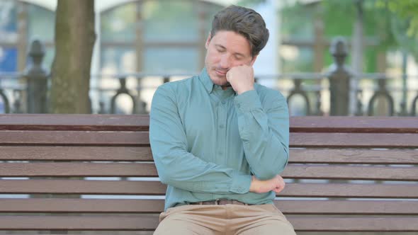 Tired Man taking Nap While Sitting Outdoor