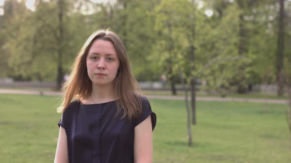 Serious Girl on Background of Summer Park.