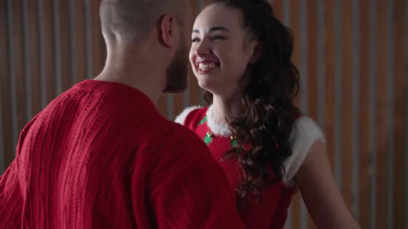 Holiday Party a Loving Husband and Wife Have Fun Dancing Near the Christmas Tree in Red Costumes on