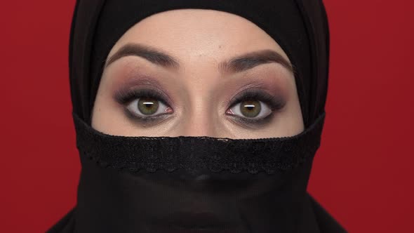 Macro Portrait of Islamic Woman in Traditional Niqab with Smoky Makeup Expressing Excitement Opening