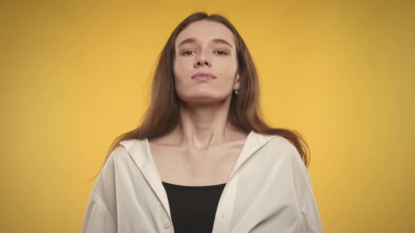 Woman Taking a Deep Breath and Smiles on a Bright Yellow Background