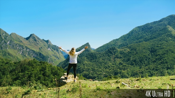 4K Rear View of Tourist Woman Walking to Mountain Summit with Beautiful Scenic View and Raising Arms