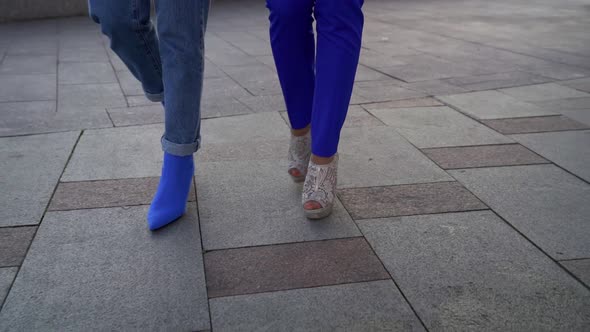 Close-up Shot of Women's Legs of Two Friends in Stylish High-heeled Shoes Walking Down the Street.