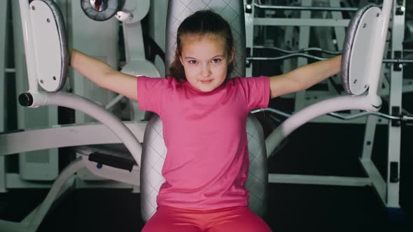 Fit Athletic Baby Girl Work Out in Butterfly Pectoral Machine for Chest Doing Her Fitness Exercise