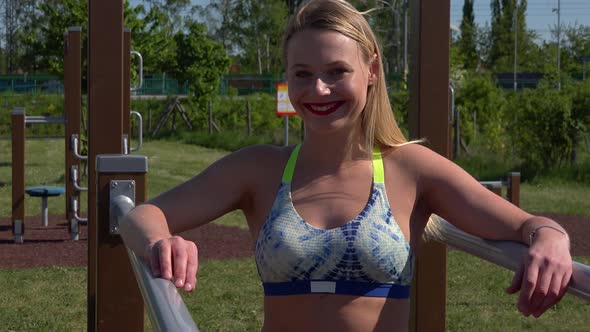 A Fit Beautiful Woman Smiles at the Camera at an Outdoor Gym - Closeup