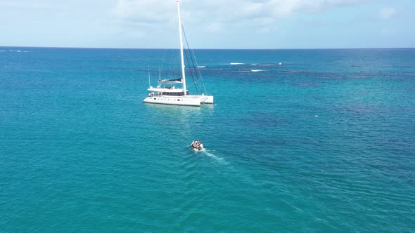 Tourist with speedboat cruising to Catamaran for Diving in blue Caribbean Sea during sunny day