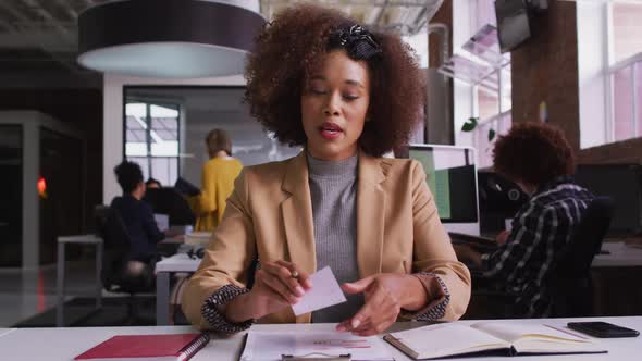 Happy mixed race businesswoman having video call sitting in front of computer