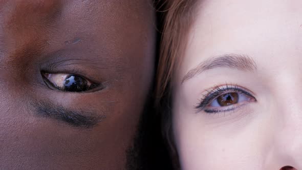 Interracial love concept. White woman and black man eyes looking at camera