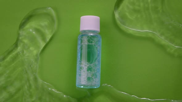 Water Flowing Slow Mo Around Moisturizing Gel Lotion on Green Background