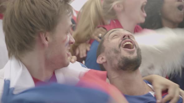 French football fans cheering in excitement at match