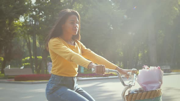 Young Active African American Woman Riding Bicycle Enjoying Great Sunny Weather in Green Public Park