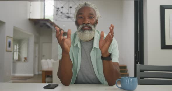 Video of happy african american senior man drinking coffee