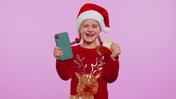 Girl Kid in Christmas Sweateruse Mobile Cell Phone Plastic Credit Bank Cards Win Calebrate Wow