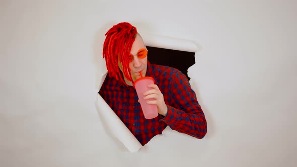 Young Man in Red Plaid Shirt Drinking Through Soft Drink Straw in Hole of White Background