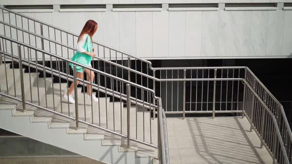 Happy Slim Woman Actively Dancing While Walking down the stairs.