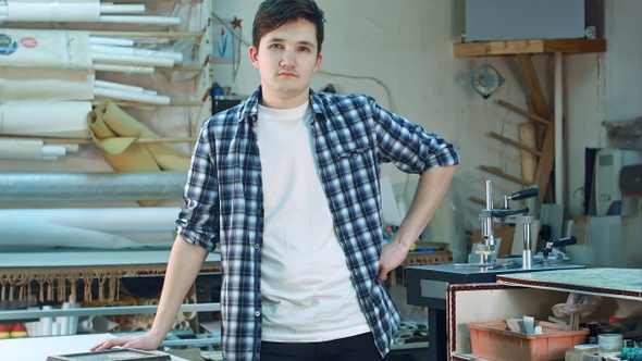 Portrait of a young male worker standing and looking at