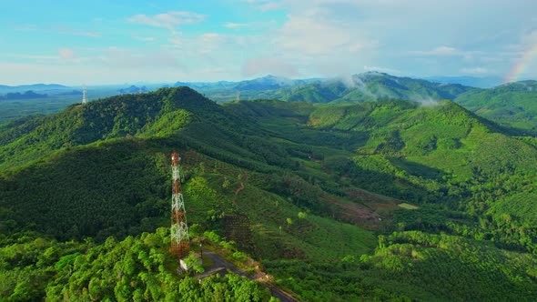 Aerial view over telecommunication towers on green mountain