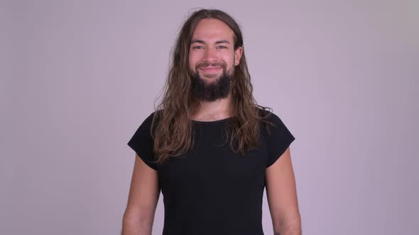 Happy Young Bearded Hipster Man with Long Hair Giving Thumbs Up