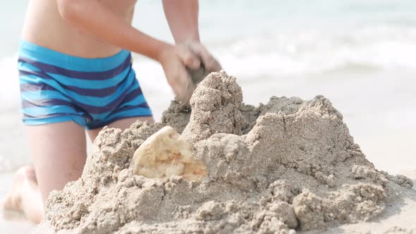 Close Up Hands Little Blonde Boy Playing with Sand on Beach Ocean Sea