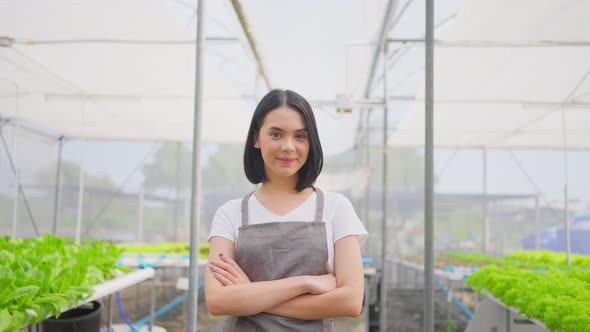 Asian woman farmer owner working in vegetables hydroponic farm with happiness and looking at camera.