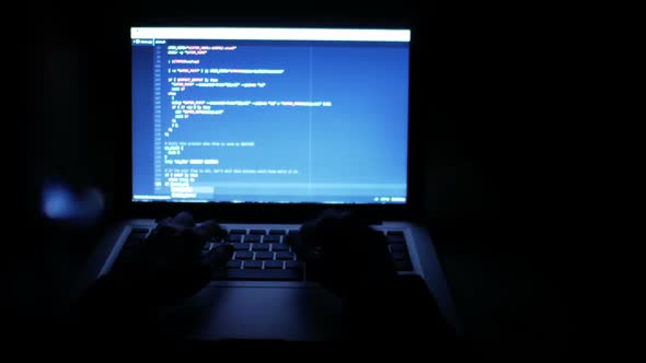 Programmer Typing Code On Laptop At Night