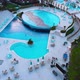 Flight Over the Beach with Umbrellas Towards the Pool in a Luxury Hotel - VideoHive Item for Sale