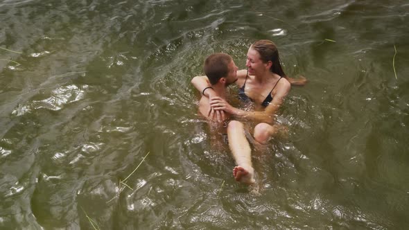 Caucasian couple having a good time on a trip to the mountains, wearing bathing suits and standing i