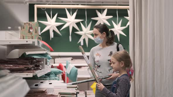 Woman with Daughter Buying Xmas Wrapping Paper