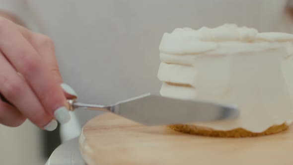 Closeup of a Pastry Chef Turns the Table and Smears the Cake with Whipped Cream