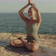 Blond Beautiful Young Caucasian Girl Meditating on a Cliff in Front of the Sea or Ocean - VideoHive Item for Sale