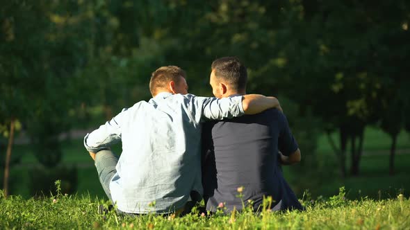 Man Hugging Friend, Enjoying Leisure Time at Sunny Park, Back View, Togetherness