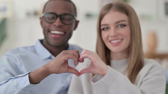 Attractive Mixed Race Couple Holding Hands Together in Heart Shape
