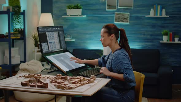 Woman Architect Using Building Model on Monitor